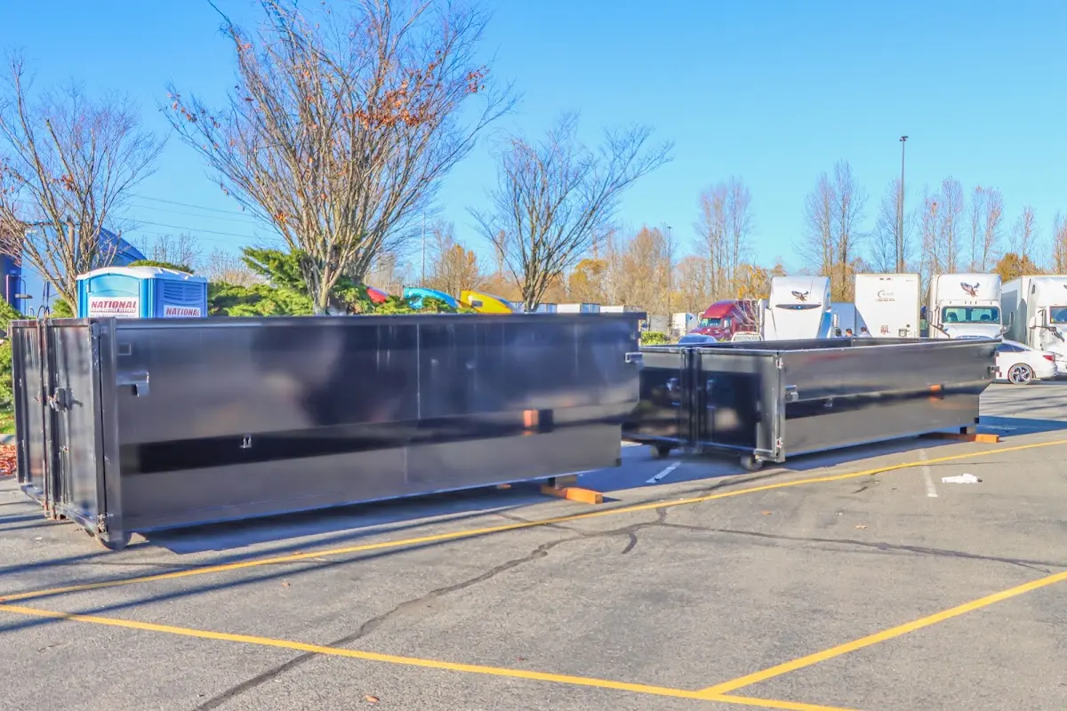 Professional dumpster rental service with roll-off container on residential driveway in Natick